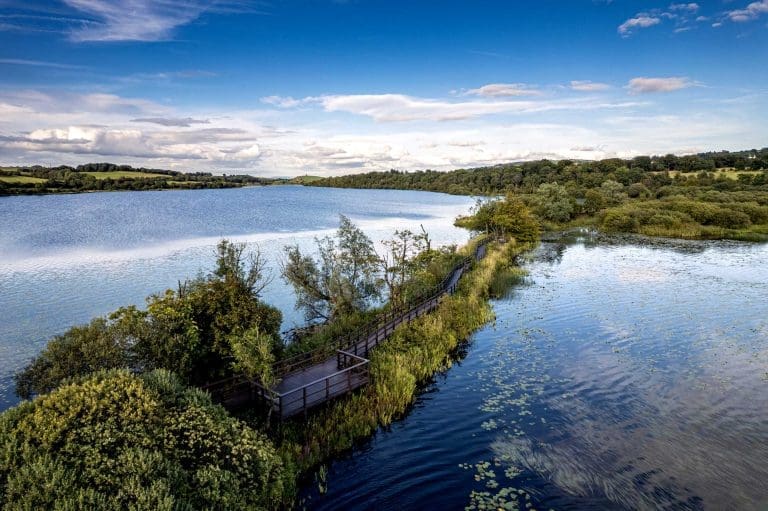 Aerial shot of a boardwalk across a loch at RSPB Lochwinnoch